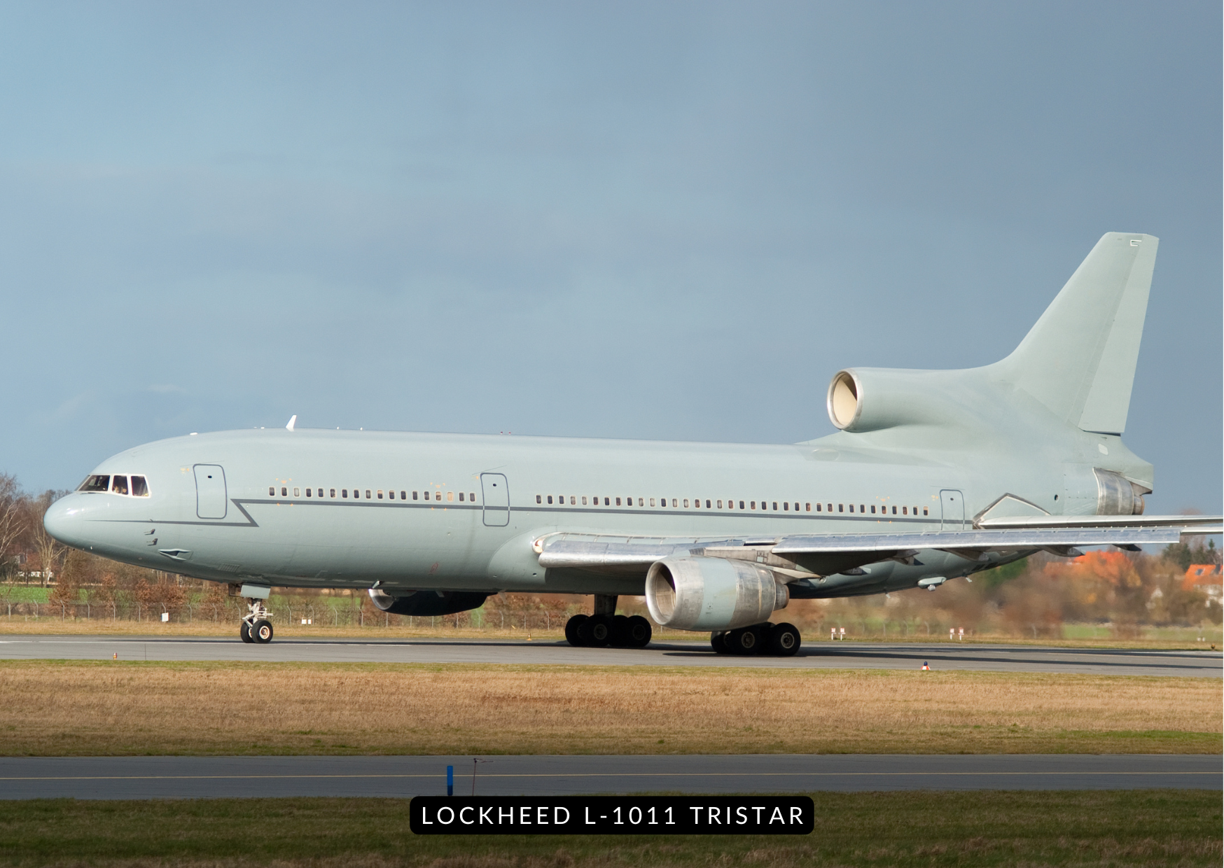 Lockheed L-1011 TriStar parked on apron, sun setting behind tail