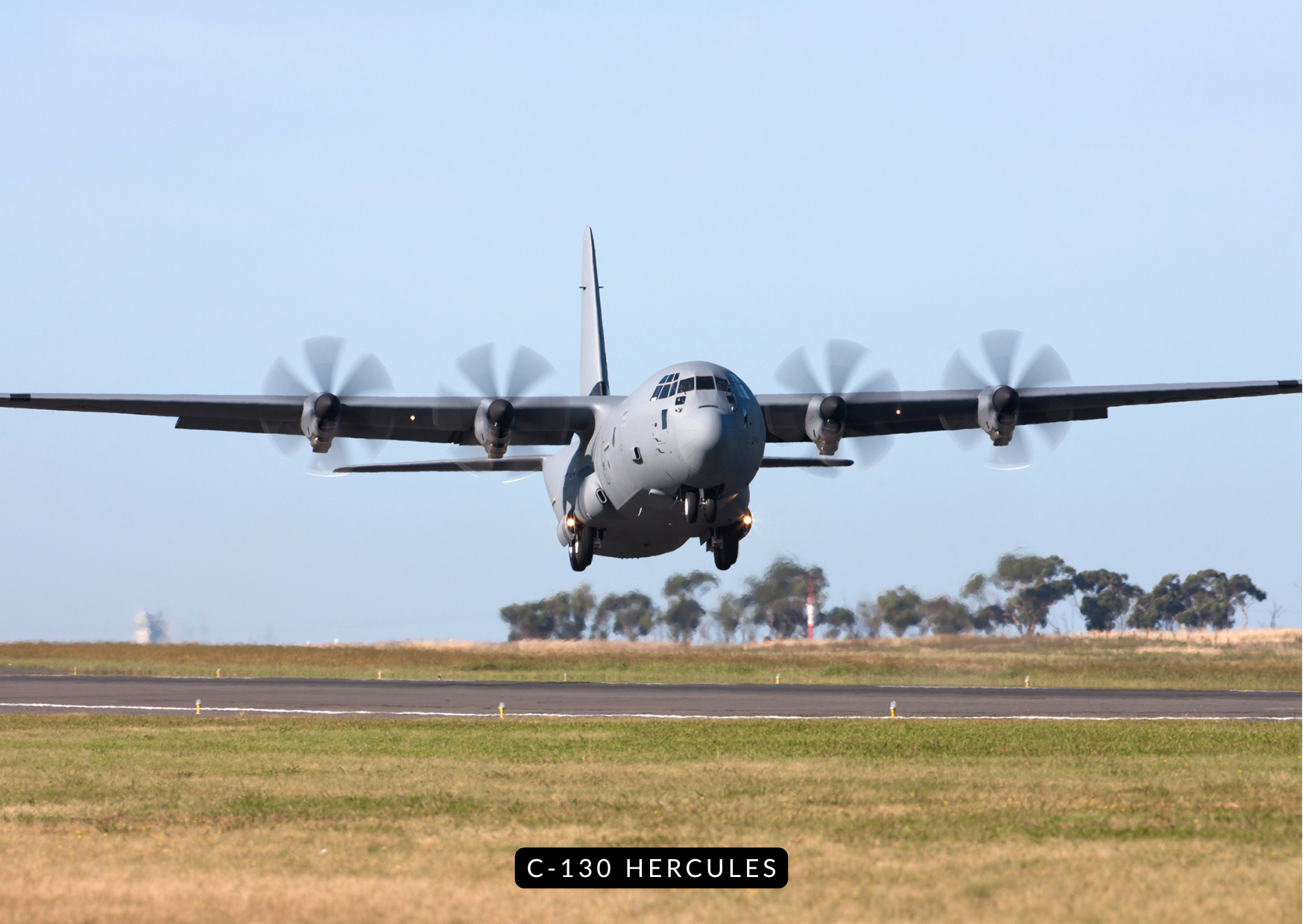 Lockheed C-130 Hercules flying low over desert terrain